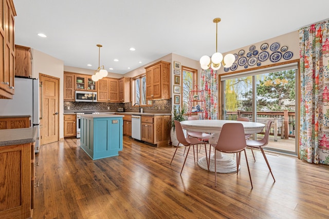 kitchen with white appliances, plenty of natural light, tasteful backsplash, and a center island