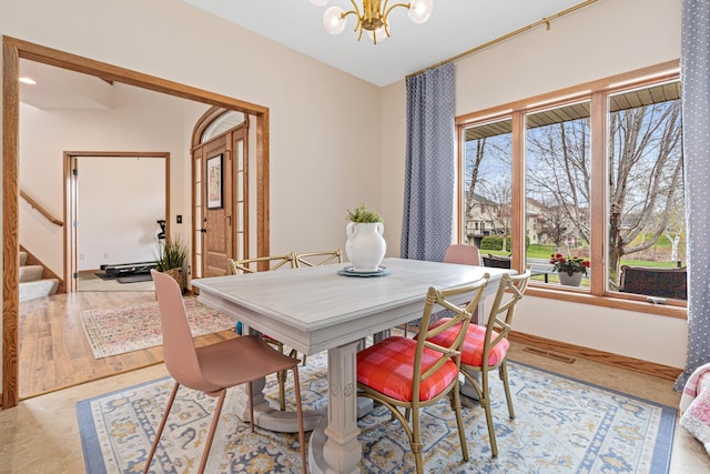 dining area featuring an inviting chandelier, stairway, and visible vents