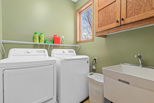 washroom featuring cabinet space, a sink, and washer and dryer
