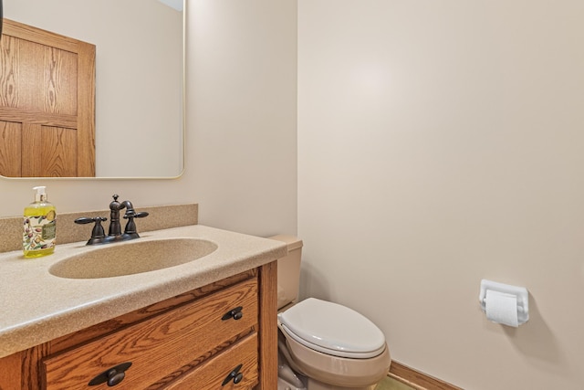 half bath featuring vanity and toilet