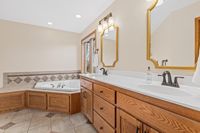 bathroom with recessed lighting, a sink, a bath, and double vanity