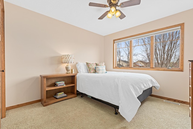 carpeted bedroom featuring a ceiling fan, baseboards, and visible vents