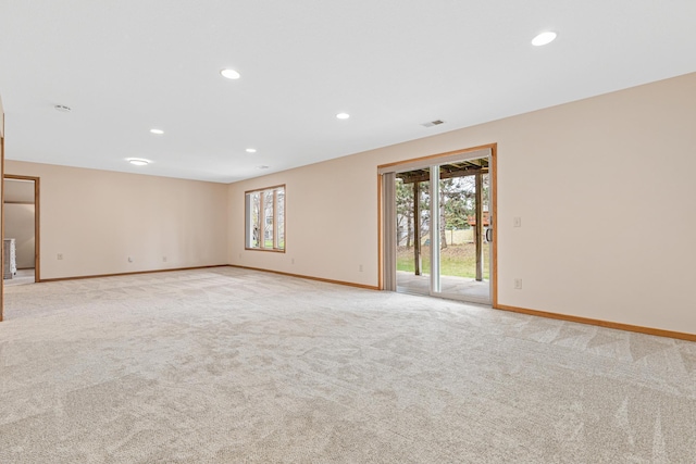 spare room featuring baseboards, light carpet, and recessed lighting