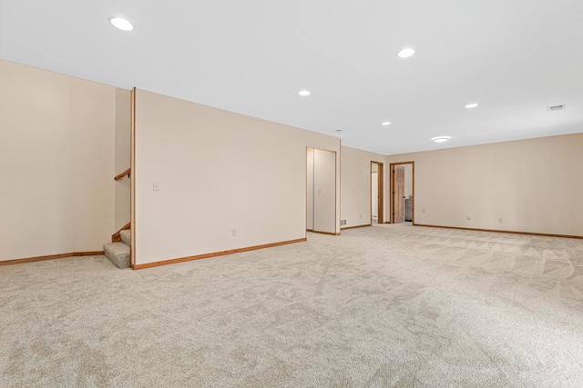 unfurnished room featuring light colored carpet, stairs, recessed lighting, baseboards, and visible vents