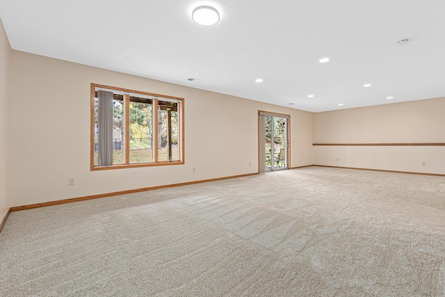spare room featuring baseboards, recessed lighting, and light carpet