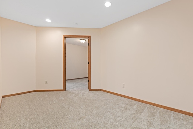 empty room featuring baseboards, recessed lighting, and light colored carpet