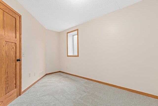 spare room featuring light colored carpet, baseboards, and visible vents