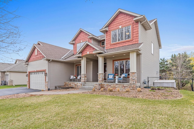 craftsman inspired home featuring a front lawn, fence, covered porch, an attached garage, and driveway