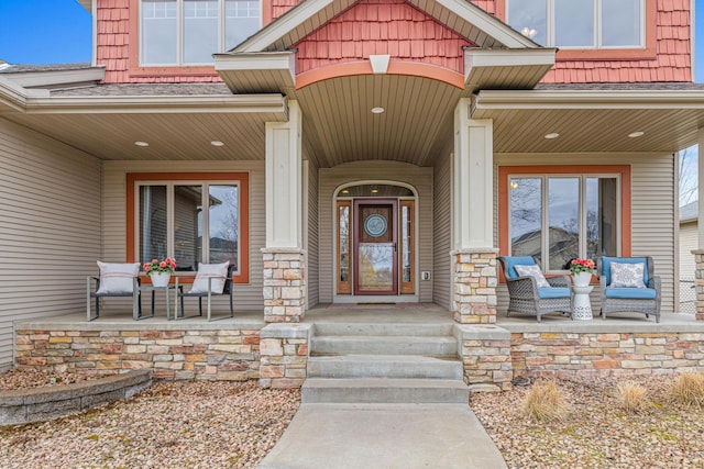 doorway to property with a porch and stone siding