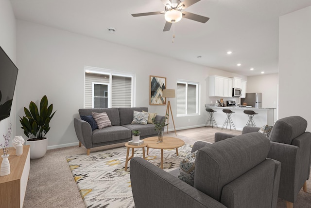 living area with ceiling fan, recessed lighting, light colored carpet, and baseboards