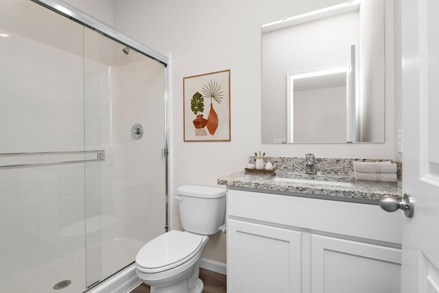 full bathroom featuring a shower stall, toilet, and vanity