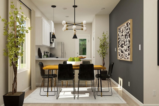 kitchen featuring a breakfast bar, a peninsula, freestanding refrigerator, light countertops, and white cabinets