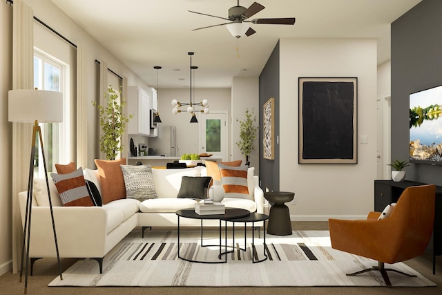 living area with ceiling fan with notable chandelier and baseboards