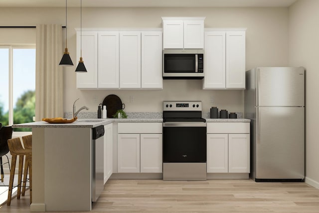 kitchen featuring light wood-type flooring, appliances with stainless steel finishes, and white cabinetry