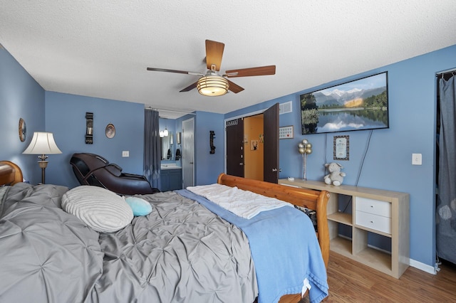 bedroom featuring visible vents, baseboards, wood finished floors, a textured ceiling, and a ceiling fan