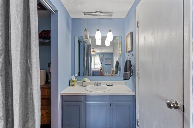 bathroom featuring vanity, connected bathroom, ceiling fan, and a textured ceiling