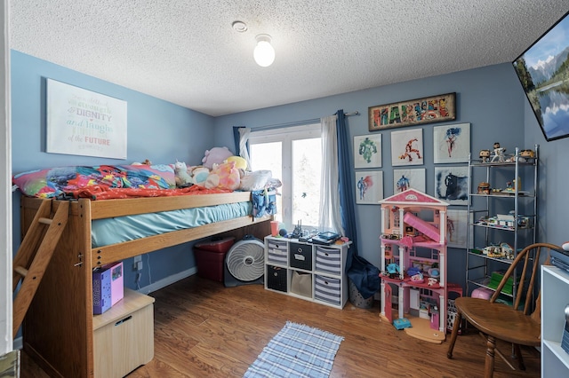 bedroom featuring a textured ceiling and wood finished floors