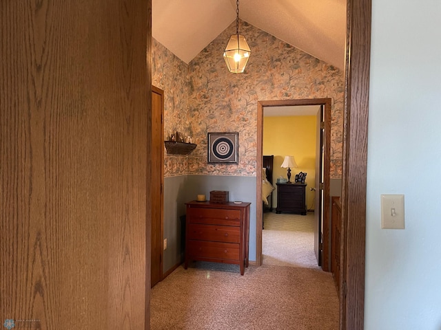 corridor with carpet and vaulted ceiling