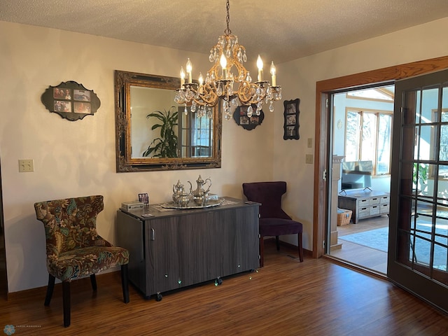 sitting room with wood finished floors, baseboards, and a textured ceiling