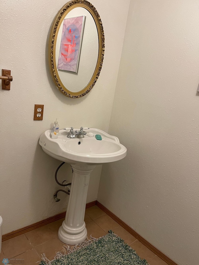 half bathroom with tile patterned flooring and baseboards