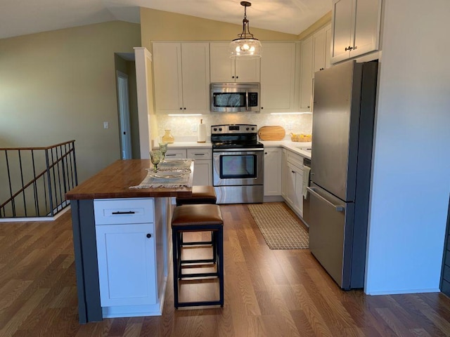 kitchen featuring vaulted ceiling, stainless steel appliances, and white cabinets