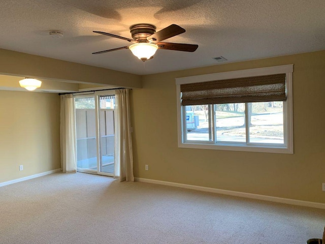 empty room featuring baseboards, visible vents, and light colored carpet