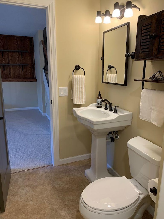 bathroom with toilet and baseboards