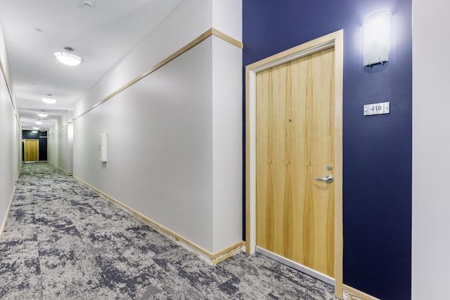 hallway with baseboards and carpet flooring