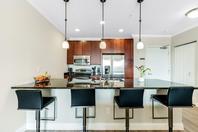 kitchen with ornamental molding, decorative light fixtures, a kitchen breakfast bar, stainless steel appliances, and a peninsula