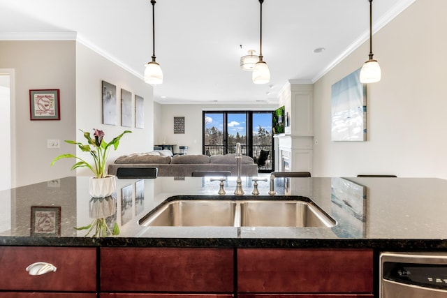 kitchen with dark stone counters, pendant lighting, stainless steel dishwasher, crown molding, and open floor plan