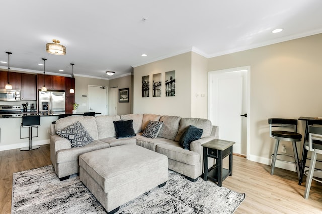 living area with recessed lighting, light wood-style flooring, baseboards, and ornamental molding