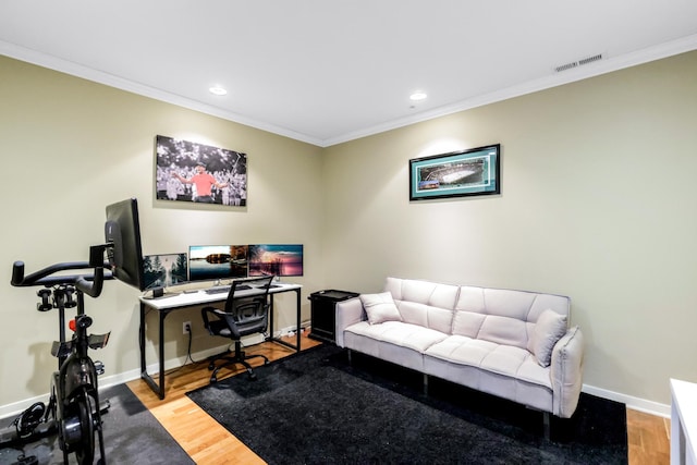 office space featuring visible vents, baseboards, wood finished floors, and ornamental molding