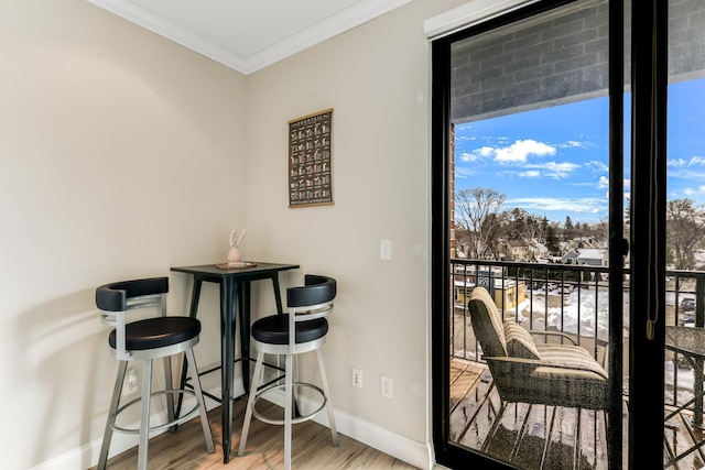 dining area featuring crown molding, wood finished floors, and baseboards