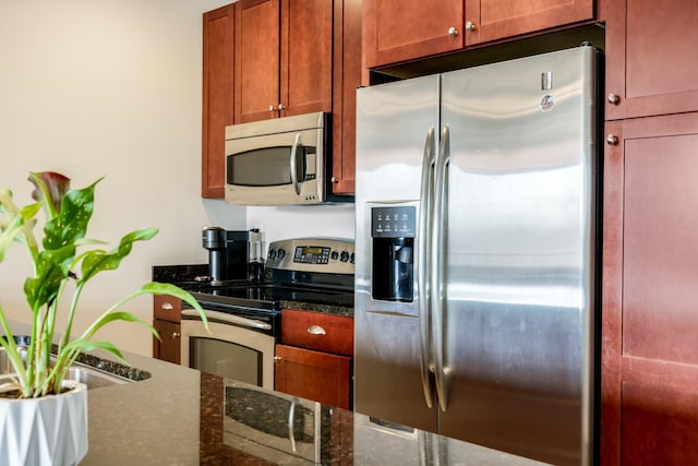 kitchen with dark stone countertops and stainless steel appliances