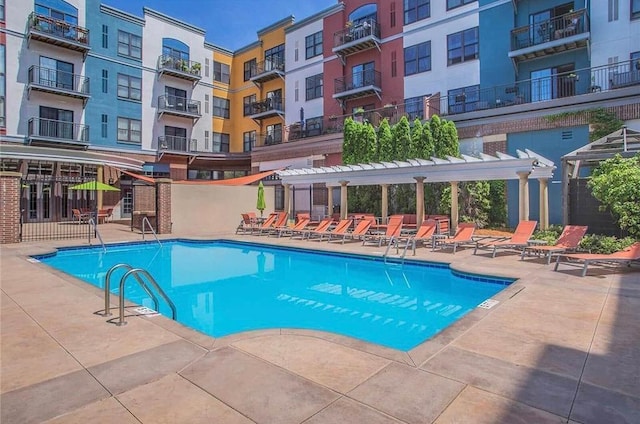 community pool with a patio area and a pergola