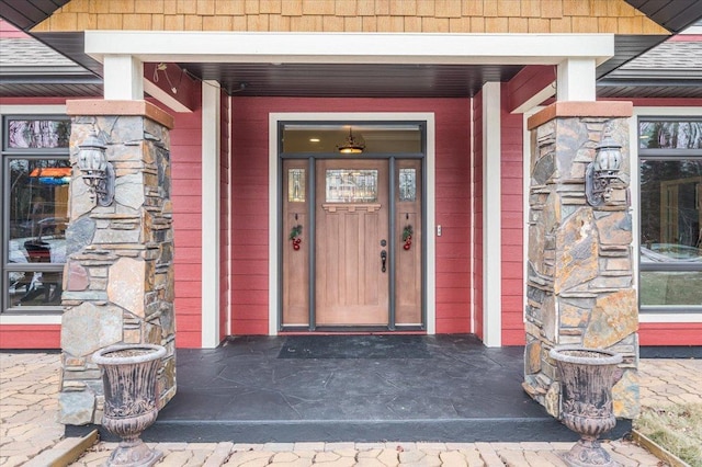 doorway to property with a shingled roof