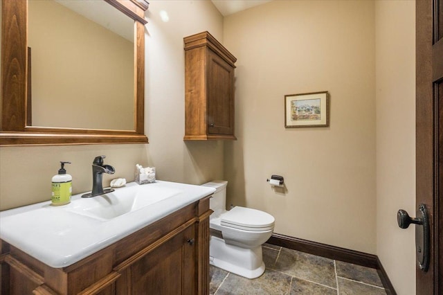 bathroom with vanity, toilet, and baseboards