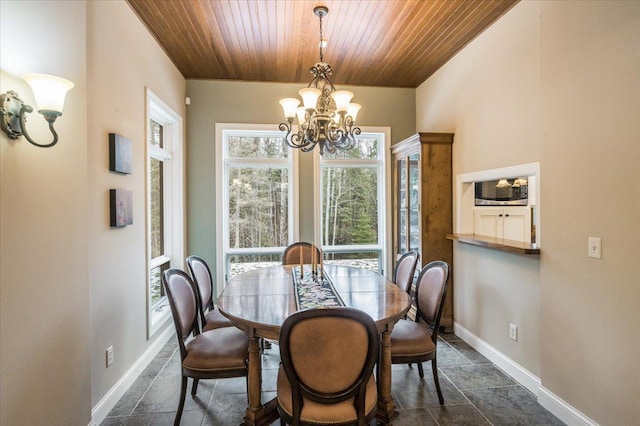 dining space with wooden ceiling, a notable chandelier, and baseboards