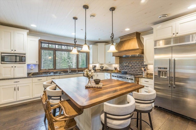 kitchen with built in appliances, wooden ceiling, a sink, dark wood finished floors, and custom range hood