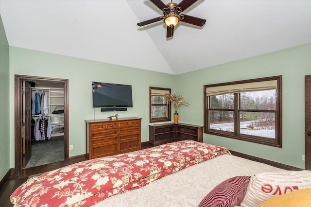 bedroom featuring lofted ceiling, a closet, a spacious closet, a ceiling fan, and baseboards