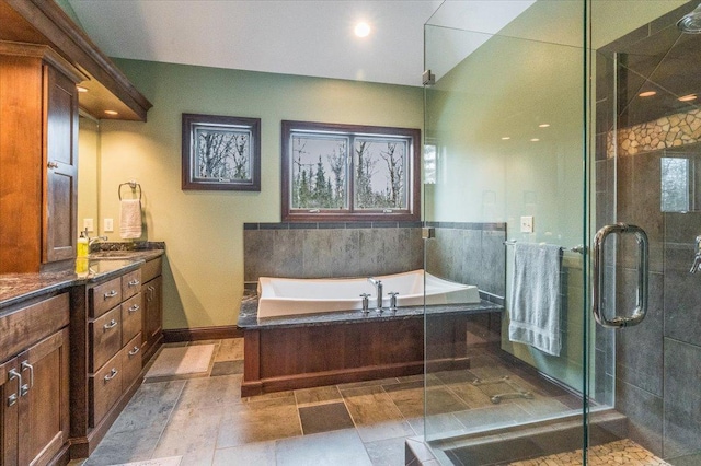 bathroom with a garden tub, plenty of natural light, a shower stall, and vanity