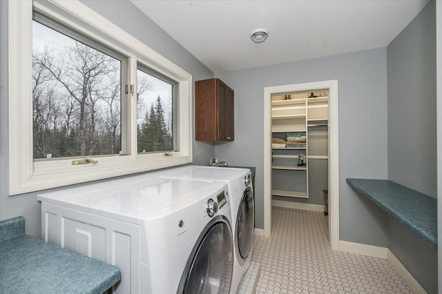 laundry room featuring visible vents, baseboards, cabinet space, and washer and dryer