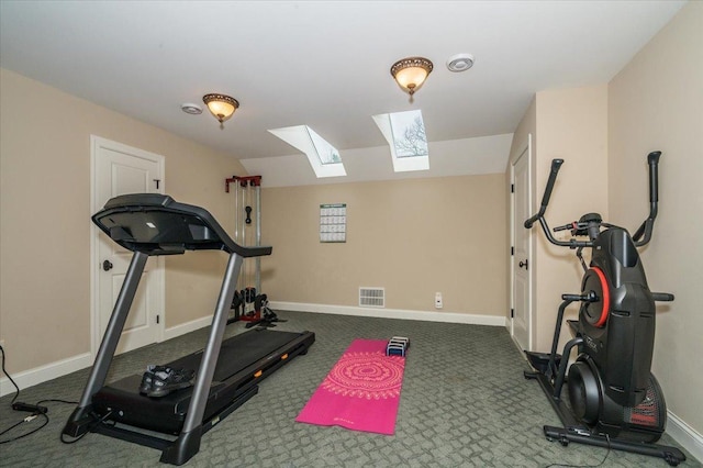 exercise room with carpet flooring, vaulted ceiling, visible vents, and baseboards