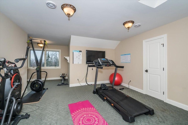 workout room with carpet flooring, vaulted ceiling, and baseboards