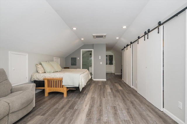 bedroom with lofted ceiling, recessed lighting, visible vents, a barn door, and wood finished floors