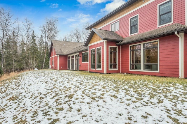 view of snow covered rear of property