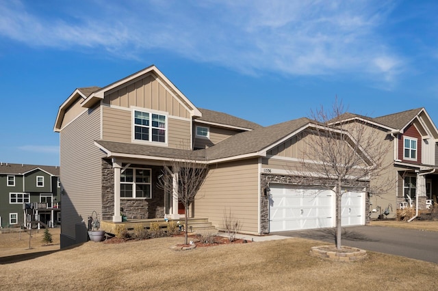 craftsman house with board and batten siding, a porch, driveway, stone siding, and an attached garage