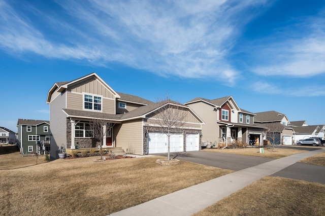 view of front of house featuring board and batten siding, a front lawn, a garage, stone siding, and driveway