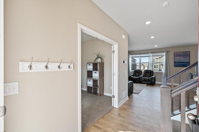 hall with stairs, recessed lighting, baseboards, and light wood-type flooring