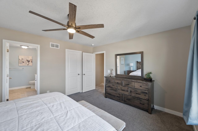 bedroom with ensuite bath, baseboards, visible vents, and carpet floors